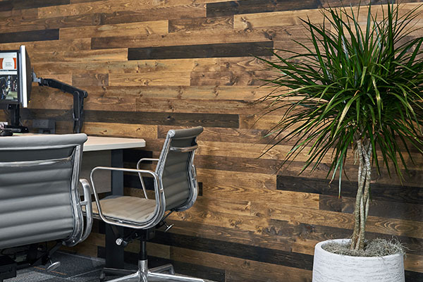 Reclaimed wood plank accent wall behind a desk in a modern office.